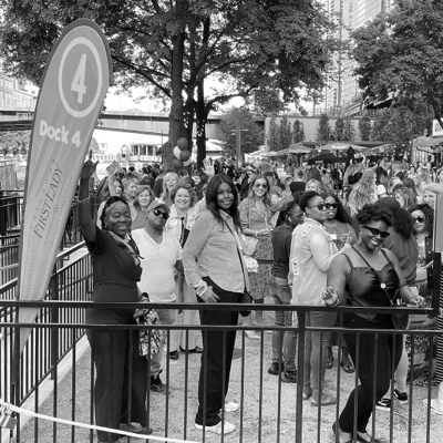 Black and white photo of a group of women standing in line to board the She Builds® event on Chicago First Lady Cruises at Dock 4.